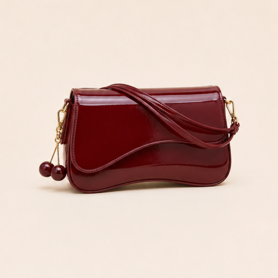 Bolso Noa rojo de charol con solapa ondulada y colgante de cerezas